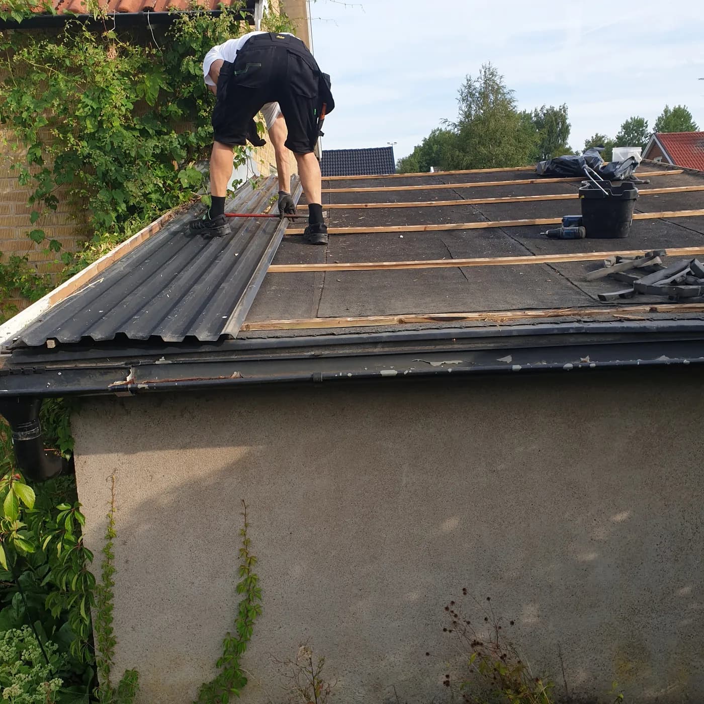 Garageplaket i Gråbo vid start av omläggningen - platen plockas av och det gamla tätskiktet syns
