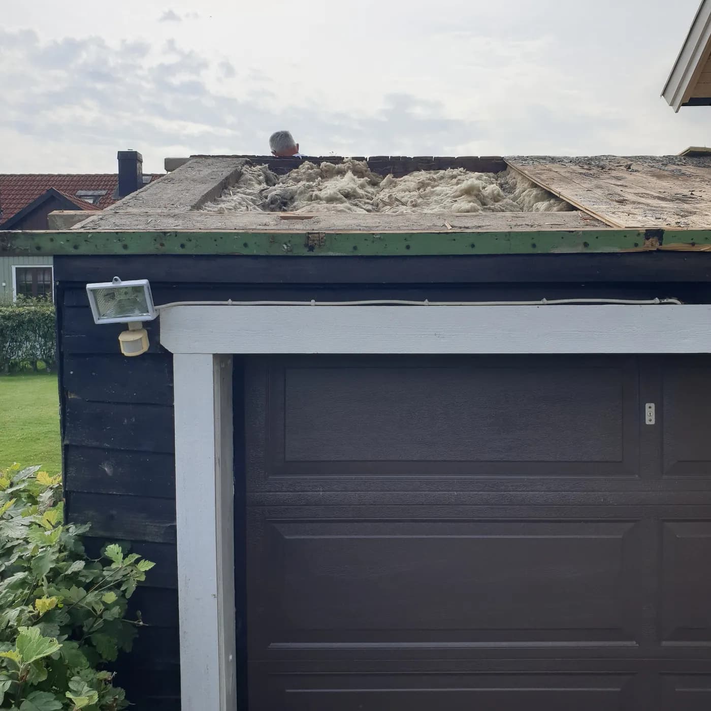 Garaget sett från infarten med öppet tak, hängrännan och stuprören nedtagna.